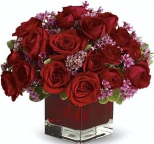 12 red roses in short vase with wax flowers