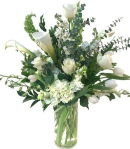white Roses, Tulips, Calla Lilies, Dendrobium Orchids, Stock and Hydrangea, accented with Eucalyptus and Bells of Ireland designed in a large cylinder. 